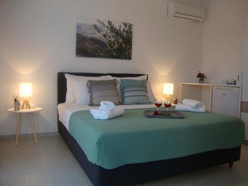 a bedroom with a bed with towels and glasses of wine at Studio Vasileios-The Best Luxury Guest Room in Spili in Spílion