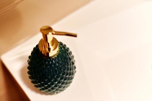 a green glass bottle with a faucet on a sink at Apartman Hertz in Imotski