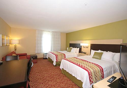 a hotel room with two beds and a desk at TownePlace Suites by Marriott Aiken Whiskey Road in Aiken