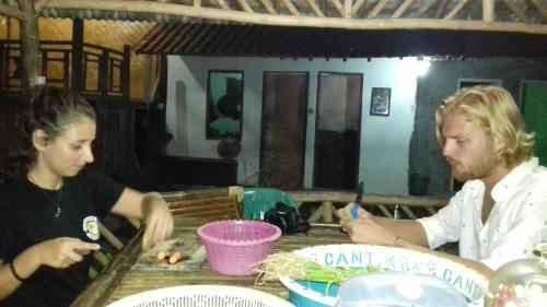 a man and a woman sitting at a table with food at De Salak Homestay in Bogor