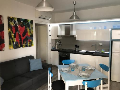 een keuken en een woonkamer met een tafel en een bank bij A Casa di Leo in San Benedetto del Tronto