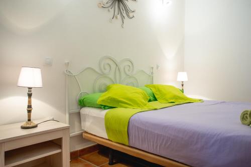 コティージョにあるCasa Checa Apartment 2のベッドルーム1室(黄色と緑の枕が付いたベッド1台付)