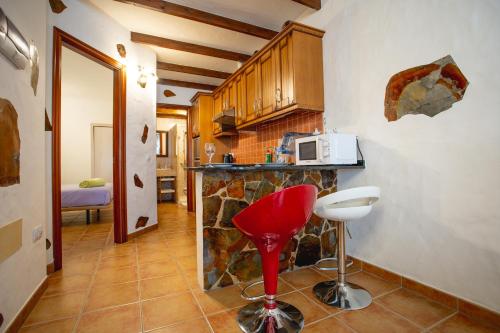 a kitchen with a red stool and a microwave at Casa Checa Apartment 2 in Cotillo