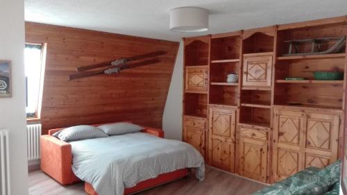 ピーラにあるAppartamento con terrazza a Pilaの木製の壁のベッドルーム1室(ベッド1台付)