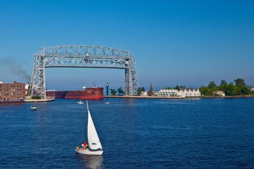 a sailboat in the water in front of a bridge at South Pier Inn in Duluth