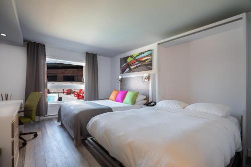 a hotel room with two beds and a window at Hotel V in Gatineau