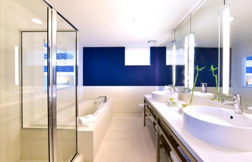
a bathroom with two sinks and a large mirror at Pestana South Beach Hotel in Miami Beach
