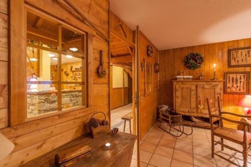 ランスヴィラールにあるRésidence Les Balcons De Val Cenis Le Hautの木製の壁の客室で、テーブルと椅子が備わります。