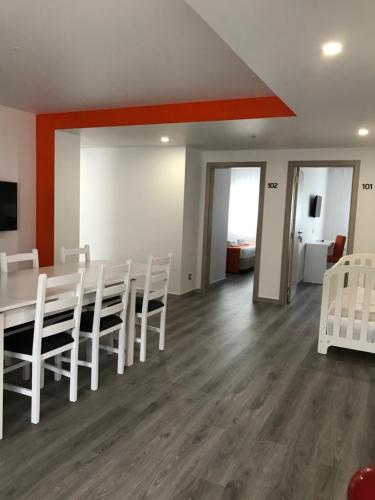 a dining room with a table and white chairs at PinoyHouse Fatima in Fátima