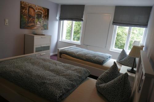 a bedroom with two beds and two windows at Ferienwohnung am Markt in Biesenthal