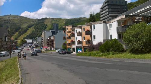 a city street with people walking down the street at Les Aliziers in Super Besse