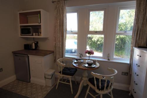 a kitchen with a table and chairs and a window at Farfield in Threshfield