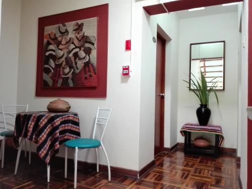 a dining room with a table and chairs and a painting at Los Q'eros in Lima