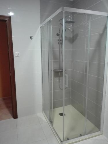 a shower with a glass door in a bathroom at Alojamiento A Nave in Fisterra