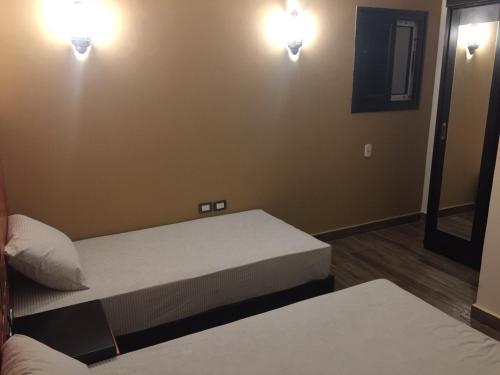 a room with two beds and two lights on the wall at H100 Pyramids View in Giza