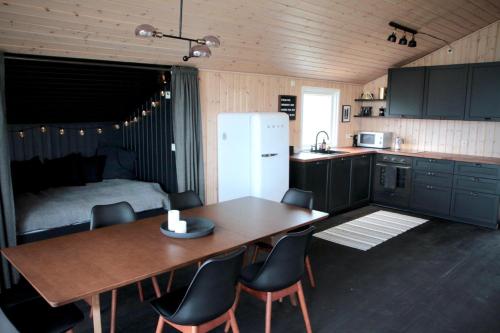 a kitchen with a table and chairs and a bed at Hilltop Cabin Hekla - Golden Circle - Geysir - Mountain View in Reykholt