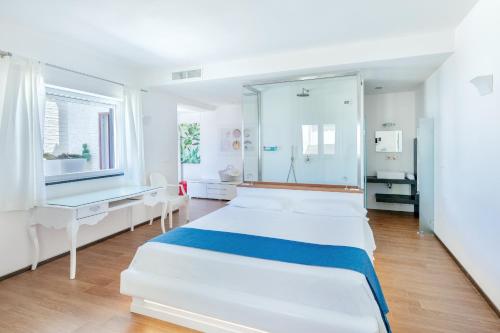 a white room with two beds and a mirror at Beauty Beach Villa in Monopoli