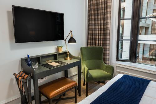 a living room with a tv and a chair at Merrion Row Hotel and Public House in New York