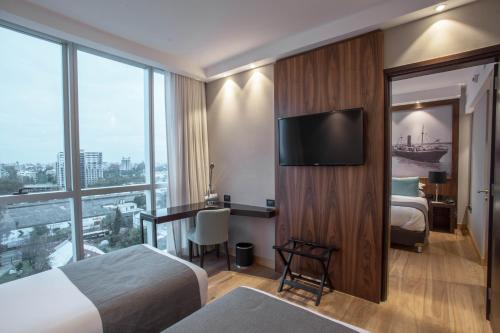 una camera d'albergo con due letti e una TV a schermo piatto di Puerto Norte Design Hotel a Rosario
