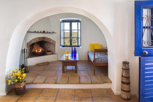 a living room with a fireplace and a table at Sfendoni House in Friligkianika