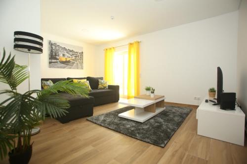 a living room with a couch and a table at cascaischillhouse in Cascais