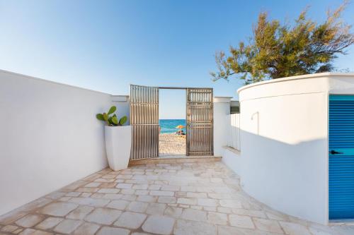 a gate to the beach with the ocean in the background at Beauty Beach Villa in Monopoli