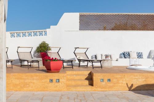 a patio with chairs and a table and a potted plant at Beauty Beach Villa in Monopoli