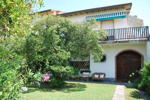 a house with a balcony and a yard at Villa Lucia in Marina di Pietrasanta