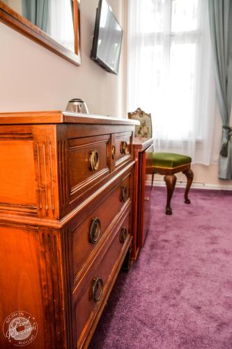 a wooden dresser with a sink in a room at Willa Sorrento in Szczecin
