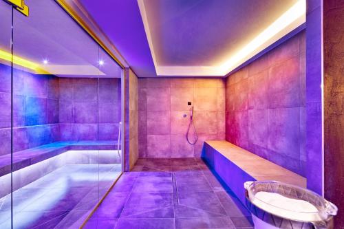 キエーネスにあるNaturhotel Die Waldruheの紫色のバスルーム(バスタブ、シャワー付)