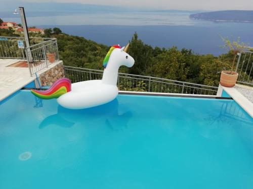 a unicorn float in a swimming pool with a view at Jovich Apartments 2 in Mošćenička Draga