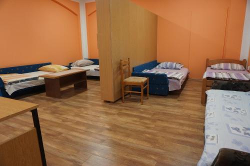una habitación con tres camas y una mesa y una silla en Apartments Bozic, en Trebinje