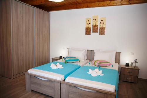 a bedroom with a large bed with two white flowers on it at Alexandros Villa in Agia Paraskevi