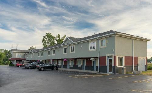 a large building with cars parked in a parking lot at Relax Inn - Batavia in Batavia