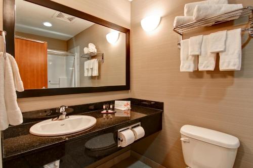 ein Badezimmer mit einem Waschbecken, einem WC und einem Spiegel in der Unterkunft Canalta Lac La Biche in Lac La Biche
