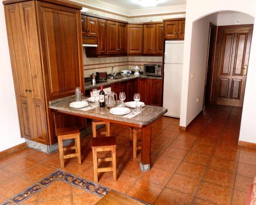 a kitchen with a table with chairs and a refrigerator at Apartamentos Isora in Frontera