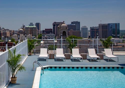 里士滿的住宿－里士滿格拉度特酒店，一个带椅子的屋顶游泳池和城市天际线