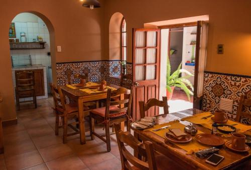 a dining room with a table and chairs and a kitchen at La Escondida Hostal in Sucre