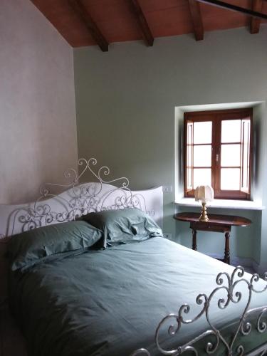 a bedroom with a metal bed with a window at B&B Villa Tonelli in Fivizzano