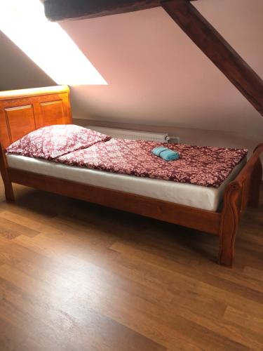 a small bed in a room with a wooden floor at Vila Mária Rapovce in Rapovce