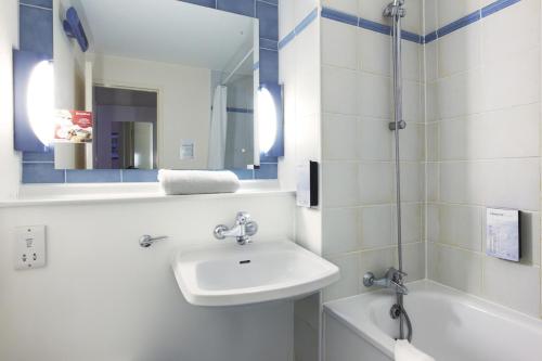a bathroom with a sink, mirror, and bathtub at Campanile Hotel Cardiff in Cardiff