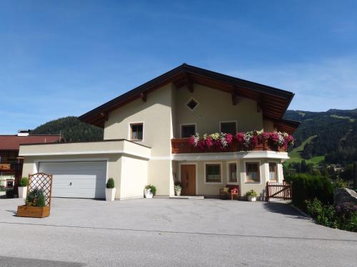 a large white house with flowers on the balcony at Appartement Fritzenwallner in Wagrain