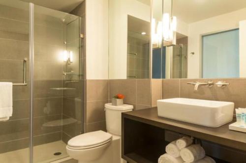 a bathroom with a toilet and a sink and a shower at Harbor House Hotel and Marina in Galveston