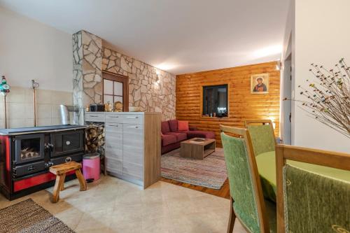 a living room with a fireplace and a red couch at Guest house Heaven in Žabljak