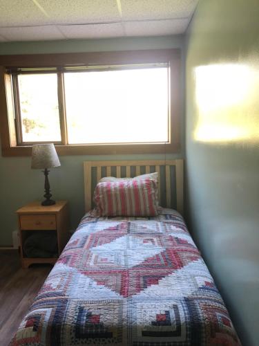 a bedroom with a bed with a quilt on it at Sawing Logzz Cabin in Copper Center