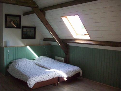 1 dormitorio con 1 cama y tragaluz en La Trouverie, en Pleines-Oeuvres