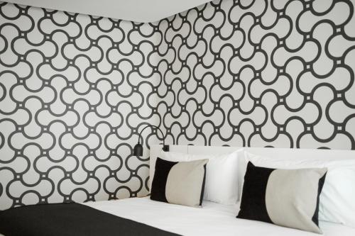 a bedroom with a black and white patterned wall at CasaSur Palermo Hotel in Buenos Aires