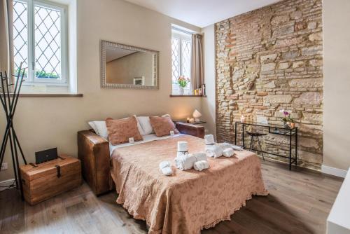 a bedroom with a bed and a stone wall at Fratta5 Luxury Apartment in Verona