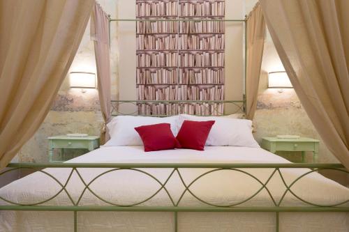 a bed with two red pillows in a room at Dimore Briganti Gallipoli Centro in Gallipoli