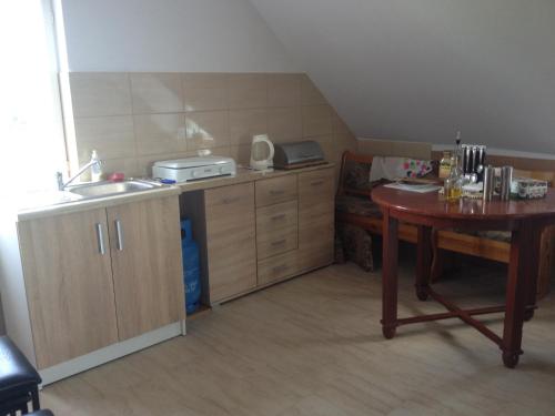 a small kitchen with a table and a sink at Agroturystyka 'Pod dębem' in Giżycko